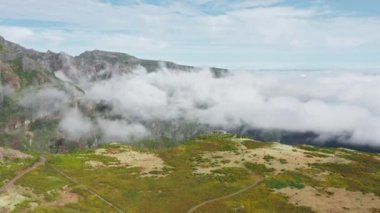 Düz tepe bulutlarda boğuluyor.