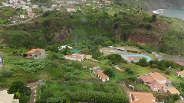 Filmagem aérea de colinas vulcânicas altas com casas costeiras no topo — Vídeo de Stock