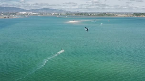 People kitesurfing in ocean, Alvor, Portugal. Kitesurfers riding kiteboards — Stock Video