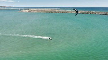 Güçlü adam Alvor, Portekiz, Avrupa 'da uçurtma kaykayıyla okyanusta süzülüyor.
