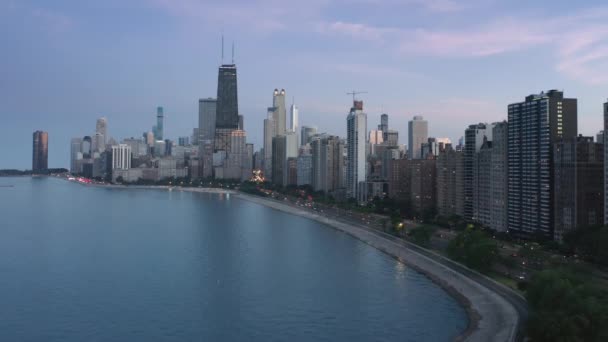 シカゴのダウンタウンの夜のシーン、ピンクの日没の背景と夕暮れ時の街路灯 — ストック動画