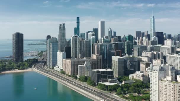 Lecące nad Chicago Downtown Skyline o wschodzie słońca, droga nad brzegiem z samochodami 4K — Wideo stockowe