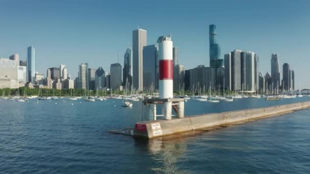 Drone che vola intorno alla torre di segnalazione bianca e rossa all'ingresso del porto turistico di Chicago 4K — Video Stock