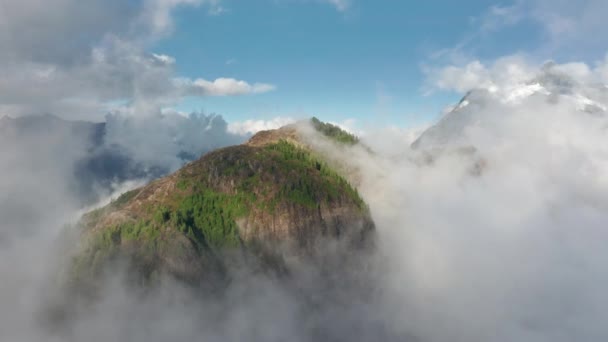 Drohne fliegt schnell über filmischem Bergwald durch sonnige Wolken 4K — Stockvideo