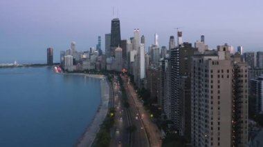 4K gece sahnesi Chicago şehir merkezi alacakaranlıkta mor mavi günbatımı arka planıyla