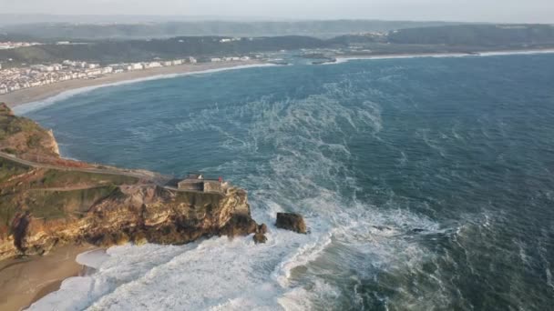 Mascella-drogato filmato drone di scogliera rocciosa gigante con Farole de Nazare in cima — Video Stock