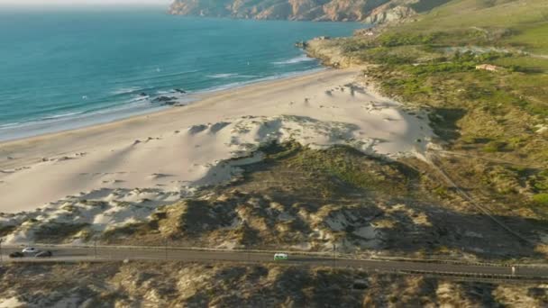 Sandy beach of Atlantic ocean of Cascais, Portugal. Autos driving on highway — Stock Video