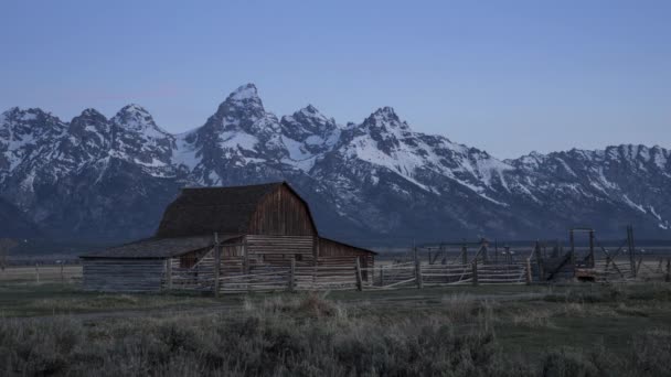 4K timelapse sunrise over Grand Teton mountains, historic wooden barn building — Stock Video