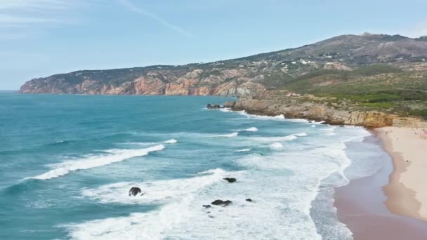 Rocce di montagna lavate dalle onde dell'oceano. Kitesurfer esercitare sport acquatici estremi — Video Stock