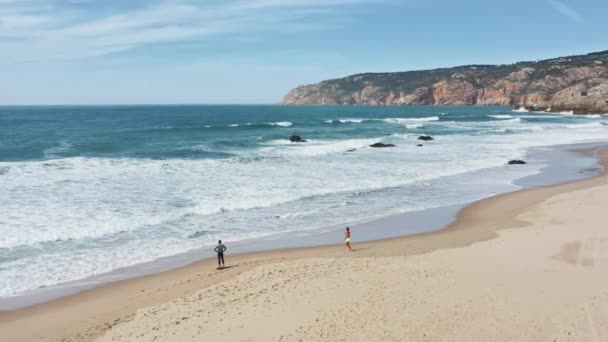 Zmęczony surfer stojący na plaży. Sportowa kobieta biegająca po piaszczystej plaży — Wideo stockowe