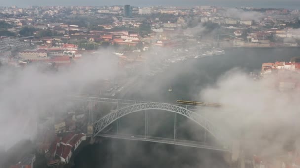 Imágenes aéreas del tren que recorre el puente Dom Luis I, entre las orillas del río — Vídeos de Stock