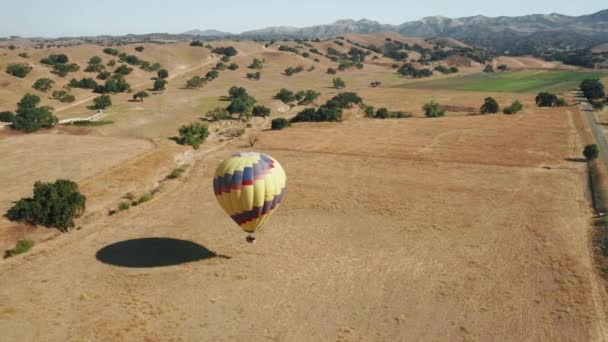Luchtfoto 4K bovenaanzicht van dalende heteluchtballon met gelukkige mensen toeristen — Stockvideo