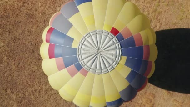 Aerial 4K top down of landed vibrant colorful hot air balloon summer California — Stock Video