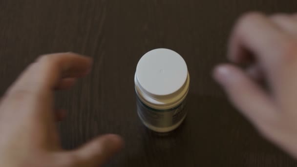 L'homme ouvre une bouteille de pilule et prend une pilule 