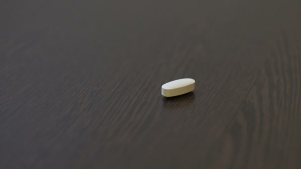 Людина приймає протизаплідні таблетки з-за столу — стокове відео