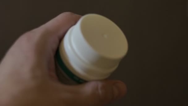 L'homme ouvre une bouteille de pilule et prend une pilule — Video
