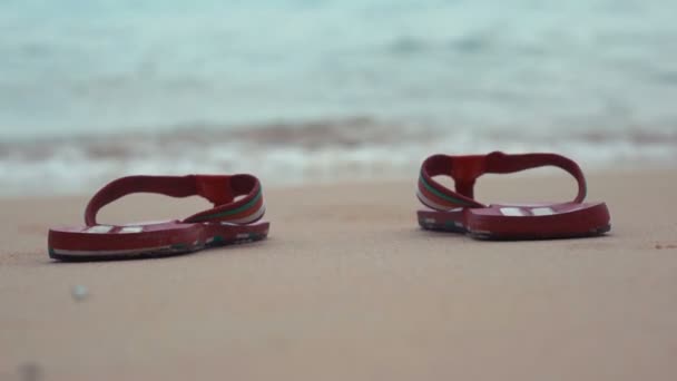 Man Flip Flops op witte zandstrand in de buurt van zee golven, niemand — Stockvideo