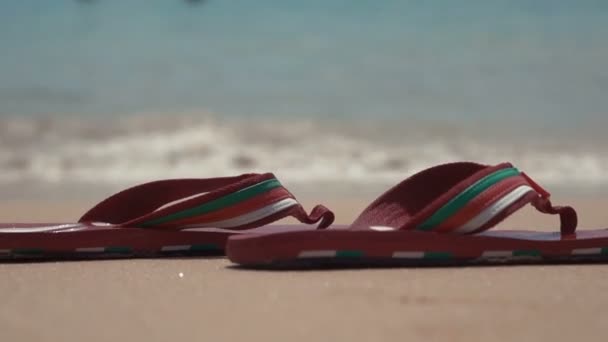 Hombre chanclas en la playa de arena blanca cerca de las olas del mar, nadie — Vídeos de Stock