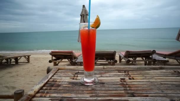 Verre avec un cocktail sur la plage par mauvais temps — Video