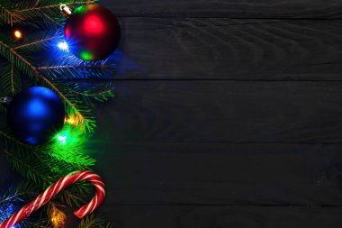 Noel zamanı, toprak, yeşil köknar dalları, kırmızı ve mavi top, şekerler, kara tahtalar