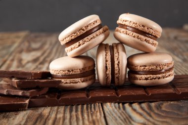 Bitter çikolata, toz kakao, Fransız macaron ve tarçın ahşap tablo