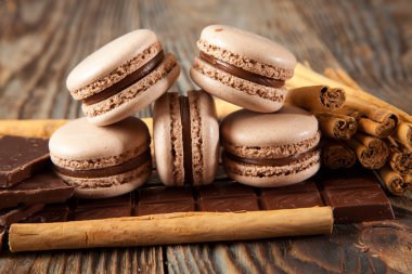 Bitter çikolata, toz kakao, Fransız macaron ve tarçın ahşap tablo