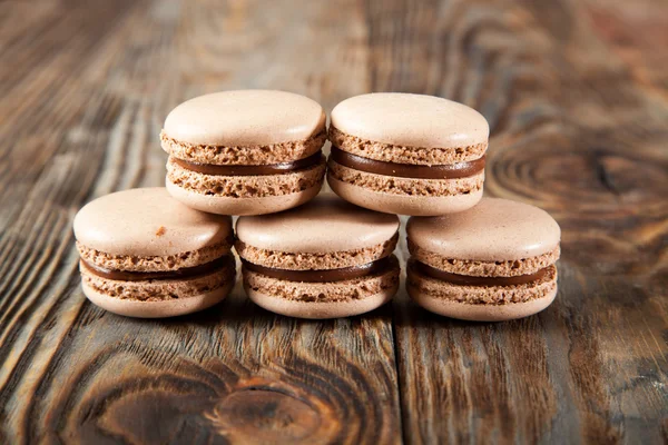Çikolata macaroons ve siyah çikolata üzerinde eski ahşap masa