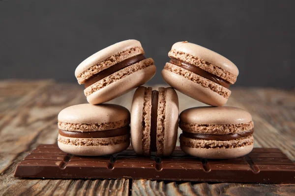 Bitter çikolata, toz kakao, Fransız macaron ve tarçın ahşap tablo