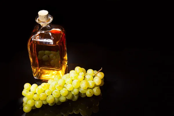 Bottle of brandy and grapes — Stock Photo, Image