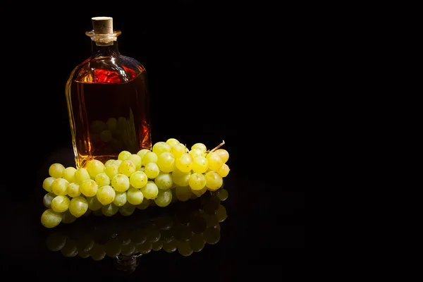 Fles van brandy en druiven — Stockfoto