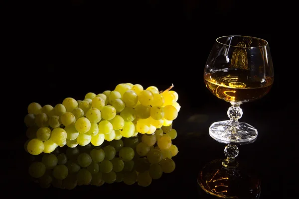 Vidro de conhaque e uvas — Fotografia de Stock