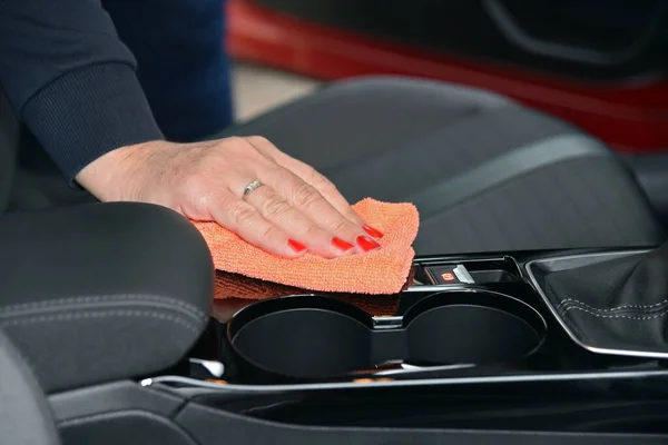 Cleaning the car console with a microfiber cloth