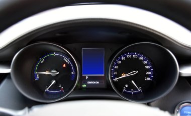 Araba hibrit bir arabanın gösterge paneli ile aydınlatılmış.