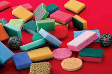 Kırmızı arka planda süngerler. Renklerin çeşitliliği.