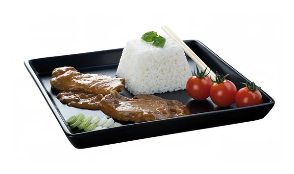 Siyah tabakta yemek. Pirinç, et ve sebze..