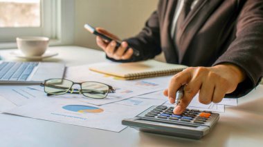 Asyalı muhasebeciler şirket bütçelerini, finansal fikirleri ve mali muhasebeyi hesaplamak için hesap makineleri kullanıyorlar.