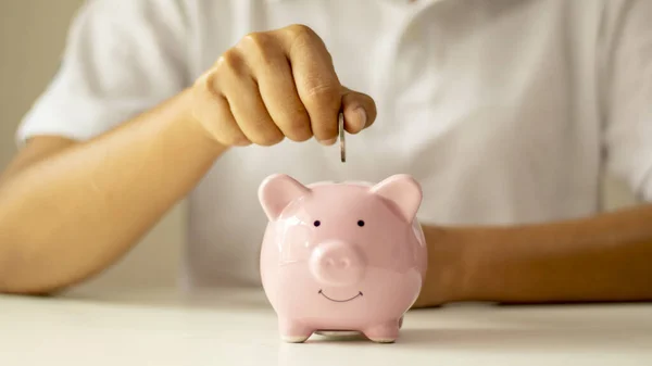 Women put money coins in a piggy piggy bank to save money and save money for future financial and money saving ideas.