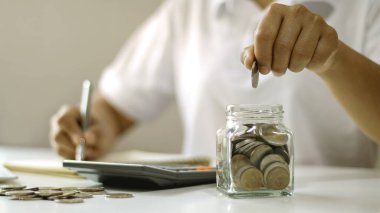 İş adamları cam şişelere para koyuyor tasarruf hesapları ve tasarruf hesapları.