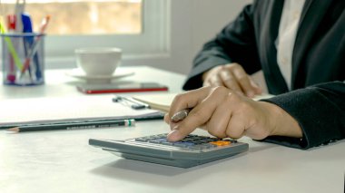 Hesap makineleri, not tutma, muhasebe raporları, maliyet hesaplama fikirleri kullanan ve para tasarrufu yapan kadınların yakın plan fotoğrafları.