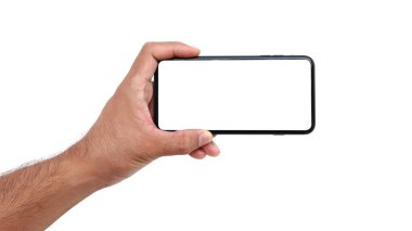 Beyaz ekranlı, beyaz arka planda siyah bir cep telefonu tutan bir kadın.