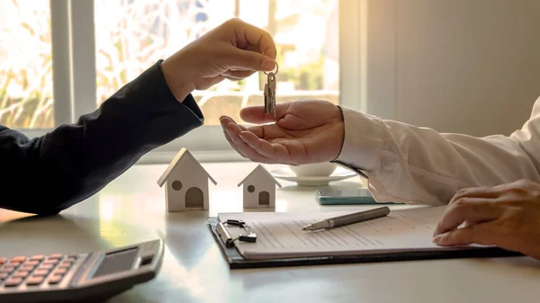 不動産エージェントは 承認された住宅ローンのリクエストフォームで不動産契約に署名した後 顧客に家の鍵を提供します 住宅ローンの概念と住宅保険 — ストック写真