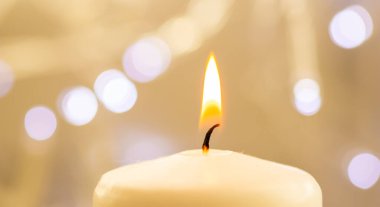Bulanık Noel ışığı arkaplanı olan yanan bir mumu kapat