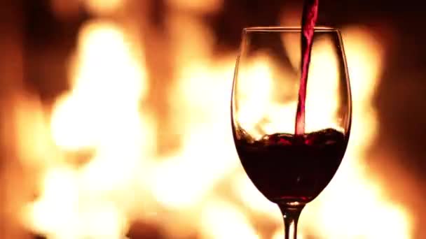 Wlewanie Czerwonego Wina Kieliszka Tle Ognia Kominku — Wideo stockowe