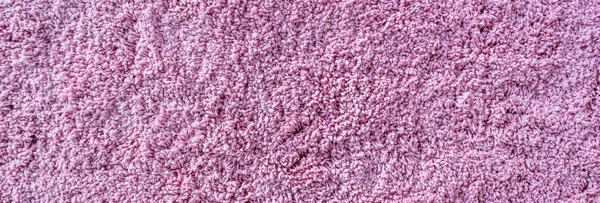 Long pile carpet texture. Abstract background of shaggy pink fibers
