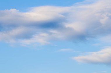 Günbatımında beyaz pembe bulutlar olan mavi gökyüzünün arka planı