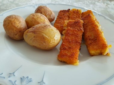 Beyaz tabakta balık çubuğu olan patates. Yemek, kapat..