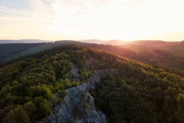 Ormanlı bir dağın üzerinde güzel, atmosferik bir güneşin doğuşunun havadan çekilmiş fotoğrafı. Sauerland, Almanya 'dan insansız hava aracı vuruldu..