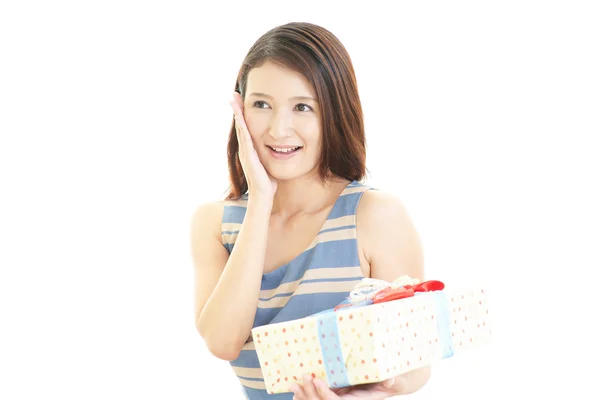 A mulher que sorri com um presente — Fotografia de Stock