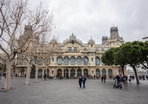 Barcelona, Spanien - 7 feb 2014: turister besöker den gamla port de barcelona byggnaden vid basen av rambla del mar på 7 feb 2014 i barcelona, Spanien. Det finns 7 miljoner besökare varje år — Stockfoto