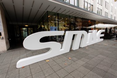 Berlin, Almanya - 12 Kasım 2014: Diş bakımı İsviçre gülümseme ile alışveriş sokak Kurfuerstendamm, Berlin, Almanya 12 Kasım 2014 alışveriş, kaldırımda 3d logo